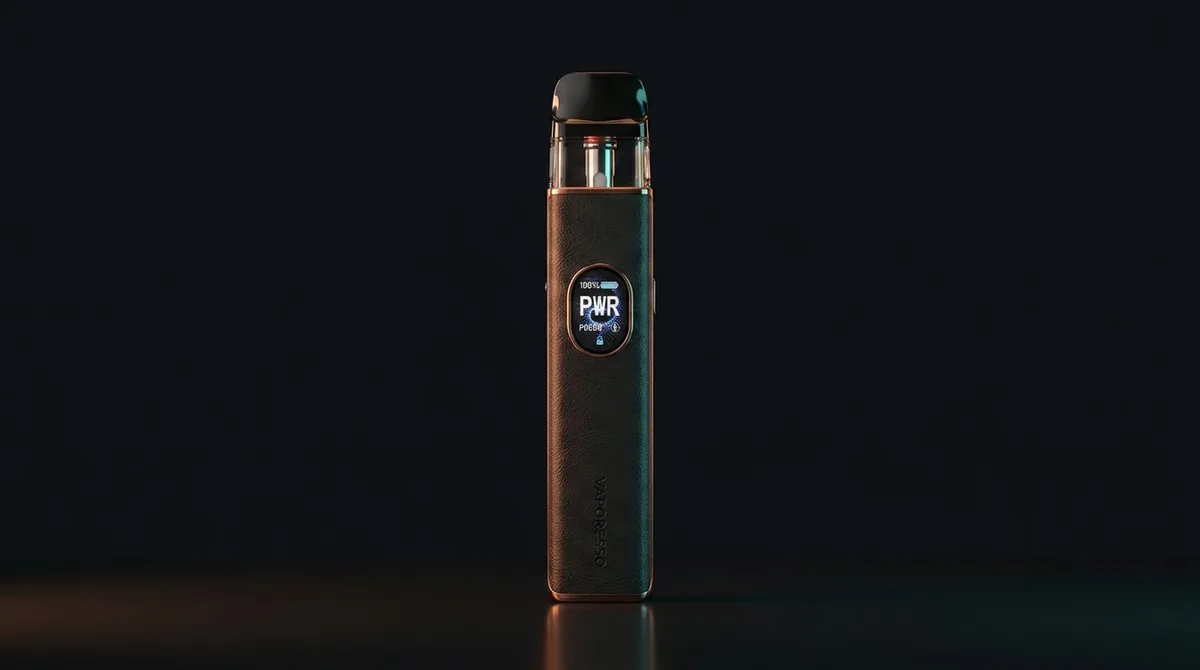 Vaporesso XROS 5 con cuerpo de piel negra y acabado en cobre y la pantalla mostrando PWR, sobre fondo oscuro de estudio.